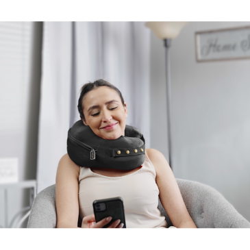 person texting while wearing comfortable neck supporting pillows for sleeping travel spine support - black