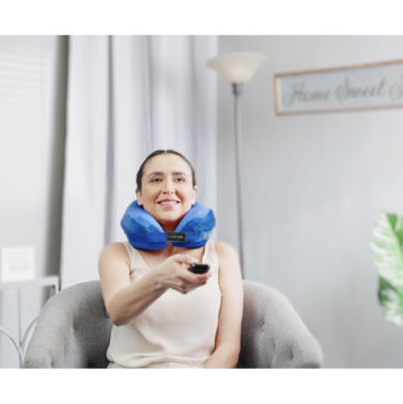 person wearing pillow for neck and back pain while watching TV - blue