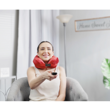 person wearing pillow for neck and back pain while watching TV - red