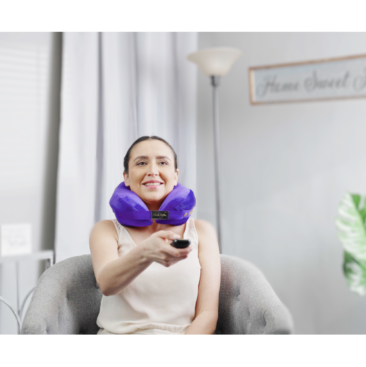 person wearing pillow for neck and back pain while watching TV - purple