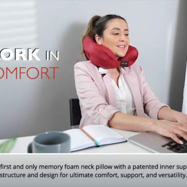 Woman using a burgundy Neck Sofa Pillow while working on her computer.